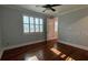 Bedroom with a ceiling fan, wood floors, baseboards, and a large window with shutters at 6301 Swanson St, Windermere, FL 34786