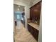 Hallway with tile flooring and brown cabinets with granite countertops at 6301 Swanson St, Windermere, FL 34786