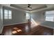 Main bedroom with a tray ceiling, wood flooring, and plantation shutters at 6301 Swanson St, Windermere, FL 34786