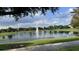 Pond with water fountain and trees, under a partly cloudy blue sky at 6301 Swanson St, Windermere, FL 34786