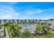 Aerial view of the complex featuring a large blue pool, lounge chairs, cabanas, and modern-style buildings at 7740 Sandy Ridge Dr # 206, Kissimmee, FL 34747
