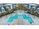 Overhead view of the complex featuring a large blue pool, lounge chairs, umbrellas, and contemporary-style buildings at 7740 Sandy Ridge Dr # 206, Kissimmee, FL 34747