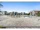 Modern community pool with light-colored pavers, many lounge chairs and umbrellas, and apartment buildings in the background at 7740 Sandy Ridge Dr # 206, Kissimmee, FL 34747