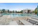 Large modern community pool and lounge chairs, along with blue-trimmed apartments and lush landscaping in the background at 7740 Sandy Ridge Dr # 206, Kissimmee, FL 34747