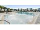 Large modern community pool with many chairs and umbrellas, with blue trimmed apartment buildings in the background at 7740 Sandy Ridge Dr # 206, Kissimmee, FL 34747