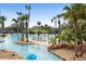 Relaxing lazy river winds through lush landscaping with palm trees, creating a serene and tropical pool atmosphere at 7740 Sandy Ridge Dr # 206, Kissimmee, FL 34747
