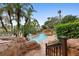 Beautiful resort-style pool surrounded by lush landscaping, rock features, and a water fall at 7740 Sandy Ridge Dr # 206, Kissimmee, FL 34747