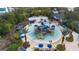 Aerial view of community waterpark featuring splash pad, lounge chairs, umbrellas, and palms at 7740 Sandy Ridge Dr # 206, Kissimmee, FL 34747