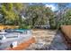 Backyard with an in-ground pool, patio space, wooden fence, and mature trees at 829 Madison Ave, Daytona Beach, FL 32114
