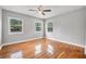Sun-filled bedroom with gleaming hardwood floors, ceiling fan, and neighborhood view at 829 Madison Ave, Daytona Beach, FL 32114