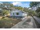 Charming exterior of light blue one story home, fenced yard, and long driveway at 829 Madison Ave, Daytona Beach, FL 32114