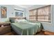 Comfortable bedroom featuring wood look floors, wooden blinds, and lots of natural light at 840 Center Ave # 9, Daytona Beach, FL 32117
