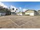 Community tennis court adjacent to well-maintained green and white buildings, shaded by mature trees under a clear sky at 840 Center Ave # 9, Daytona Beach, FL 32117