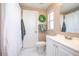 Bright bathroom features a single sink vanity, white tile floor, and shower with white curtain at 893 S Dean Cir, Deltona, FL 32738