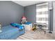 Cozy bedroom features carpeted floors, a blue bed, and a charming window with striped curtains at 893 S Dean Cir, Deltona, FL 32738