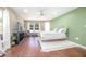 Bright main bedroom with wood floors, white ceiling fan, and large windows overlooking the yard at 893 S Dean Cir, Deltona, FL 32738