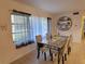 Dining room with a glass-topped table, seating for four, and natural light from the window at 906 E Wisconsin Ave, Deland, FL 32724