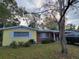 Charming single-story home with yellow siding, brick accents, and mature landscaping at 906 E Wisconsin Ave, Deland, FL 32724