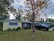 Charming single-story home featuring a yellow extension, brick facade, and mature trees in a quiet residential neighborhood at 906 E Wisconsin Ave, Deland, FL 32724