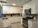 Modern kitchen with white cabinets, granite countertops, stainless steel appliances, and stylish backsplash at 906 E Wisconsin Ave, Deland, FL 32724