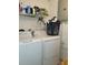 Functional laundry room with washer, dryer, and overhead storage shelving at 906 E Wisconsin Ave, Deland, FL 32724