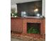 Living room brick fireplace with plants inside and a large television above the mantel at 906 E Wisconsin Ave, Deland, FL 32724