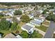 Aerial view of the community featuring well-maintained homes and lush landscaping near a scenic lake at 907 Rose Ln, The Villages, FL 32159