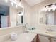 A bright bathroom features dual mirrors and a large vanity space at 907 Rose Ln, The Villages, FL 32159