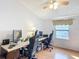 The bedroom has a ceiling fan, light-colored walls, and a window with curtains and a view of the yard at 907 Rose Ln, The Villages, FL 32159