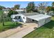 Single-story home featuring a carport, well-manicured lawn, and sidewalk at 907 Rose Ln, The Villages, FL 32159