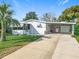Single-story home featuring a covered carport and well-manicured lawn at 907 Rose Ln, The Villages, FL 32159