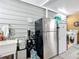A garage with stainless steel and white refrigerators and ample storage space at 907 Rose Ln, The Villages, FL 32159