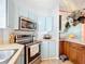 The kitchen features stainless steel appliances, including a microwave and oven, complemented by blue cabinets and light countertops at 907 Rose Ln, The Villages, FL 32159