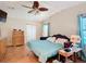 The spacious main bedroom features a ceiling fan, wood floors, light-colored walls, a dresser, and side tables at 907 Rose Ln, The Villages, FL 32159