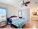 The main bedroom has wood floors, a ceiling fan, light-colored walls, and an attached bathroom at 907 Rose Ln, The Villages, FL 32159