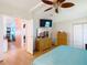 Spacious main bedroom with a ceiling fan, wood floors, a view through the house, and a dresser at 907 Rose Ln, The Villages, FL 32159