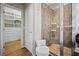 Bathroom showing shower with tiled walls and a built-in seat alongside a custom closet with shelving and drawers for organized storage at 9580 Sw 71St Loop, Ocala, FL 34481