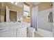 Well-lit bathroom showcases a white vanity, toilet, and bathtub with a shower, complemented by neutral-toned walls and a window at 9580 Sw 71St Loop, Ocala, FL 34481