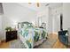 Cozy bedroom features wood floors, a vibrant leaf patterned comforter, and neutral walls for a bright and inviting ambiance at 9580 Sw 71St Loop, Ocala, FL 34481