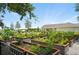 Vibrant community garden featuring raised garden beds with a variety of plants and a covered pavilion in the background at 9580 Sw 71St Loop, Ocala, FL 34481