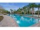 Large community pool surrounded by palm trees and brick deck, perfect for recreation and relaxation at 9580 Sw 71St Loop, Ocala, FL 34481