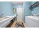 Well-lit laundry room with blue walls features a utility sink, washer, and dryer, blending functionality and style at 9580 Sw 71St Loop, Ocala, FL 34481