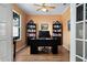 Well-lit office space with hardwood floors, built-in bookshelves, and a modern desk at 9580 Sw 71St Loop, Ocala, FL 34481