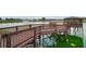 A picturesque wooden boardwalk leading to a gazebo on a pond with a fountain at 9580 Sw 71St Loop, Ocala, FL 34481