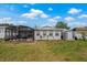 Large backyard with a screened patio, a storage shed, and lush grass at 1074 Abeline Dr, Deltona, FL 32725
