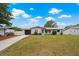 Charming single-story home featuring a well-manicured lawn, attached garage, and inviting front entrance at 1074 Abeline Dr, Deltona, FL 32725