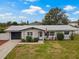 Charming single-story home featuring a well-maintained lawn, lovely landscaping, and an attached garage at 1074 Abeline Dr, Deltona, FL 32725