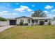 Charming single-story home featuring a well-maintained lawn, lovely landscaping, and an attached garage at 1074 Abeline Dr, Deltona, FL 32725