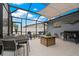 Spacious screened patio featuring a dining set, comfortable seating, and an outdoor grill at 1074 Abeline Dr, Deltona, FL 32725