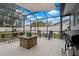 Spacious screened patio featuring a dining set, comfortable seating, and an outdoor grill at 1074 Abeline Dr, Deltona, FL 32725